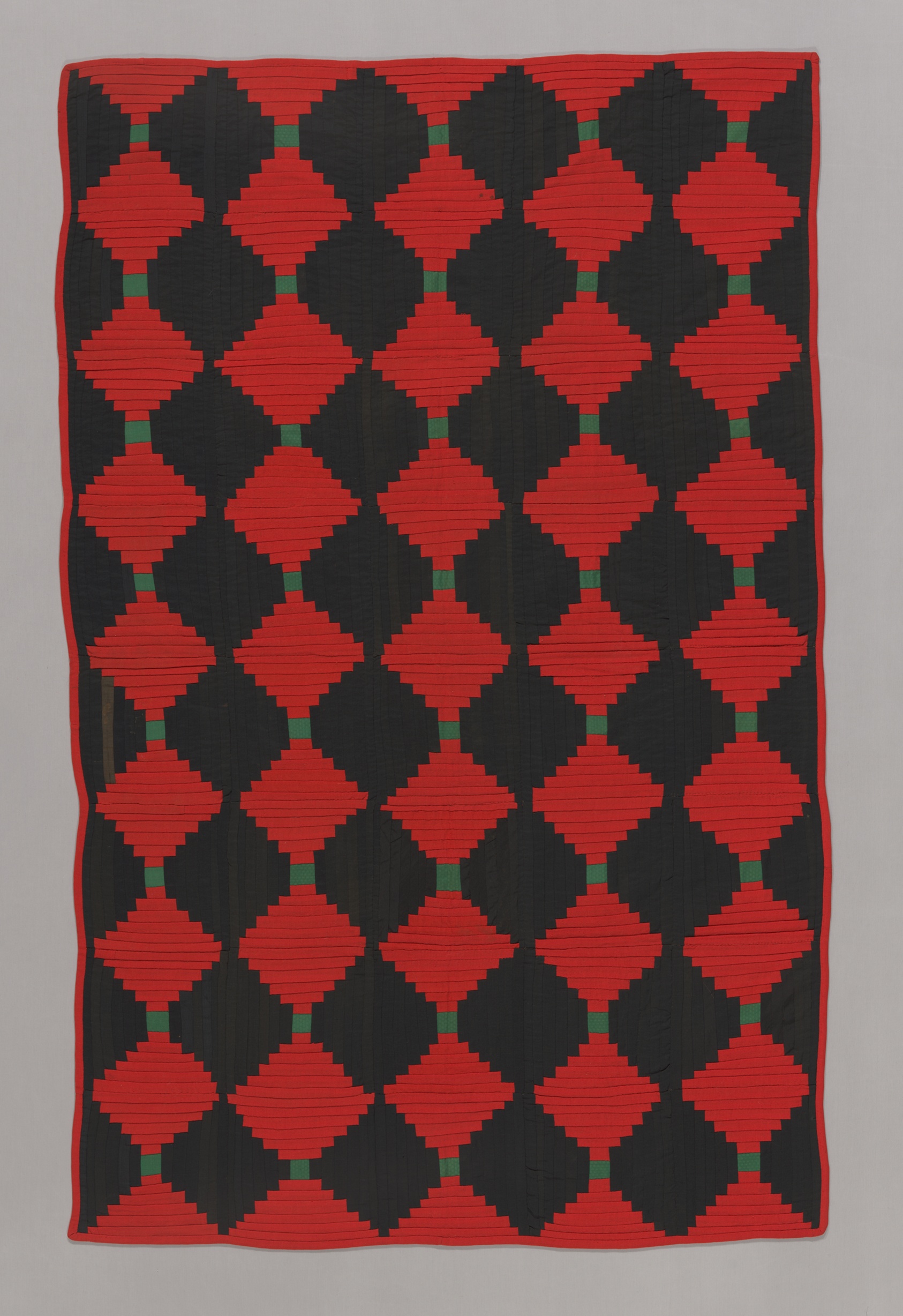 Red and dark wool strips in a Courthouse Steps quilt